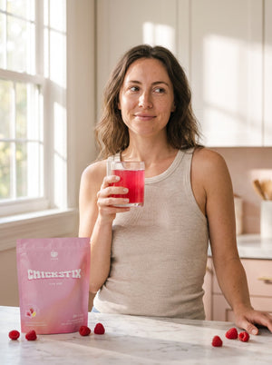 Woman holding a glass of CHICKSTIX in morning light
