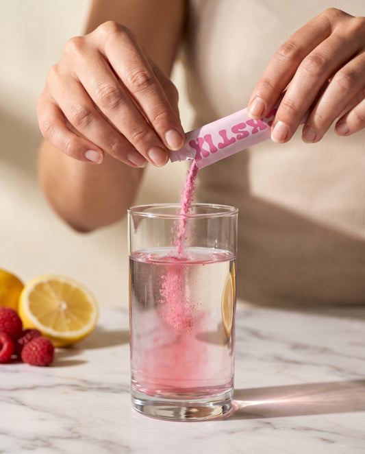 Tearing a CHICKSTIX stick pack over a glass of water